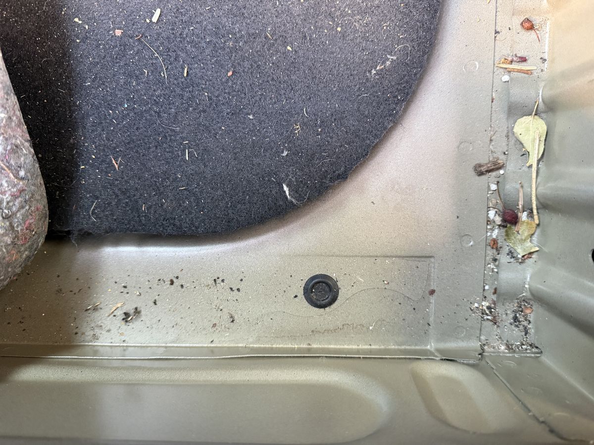 Freigelegtes Heckabschlussblech eines grauen Vans, Akte mit 13.298,81 Euro Instandsetzungskosten